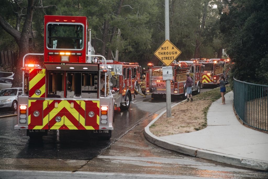 Firemen respond to a neighborhood fire with trucks and lights